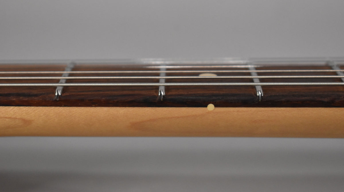 Close-up of the guitar's maple neck and dark rosewood fretboard, showing the 5th fret dot marker and side dot.