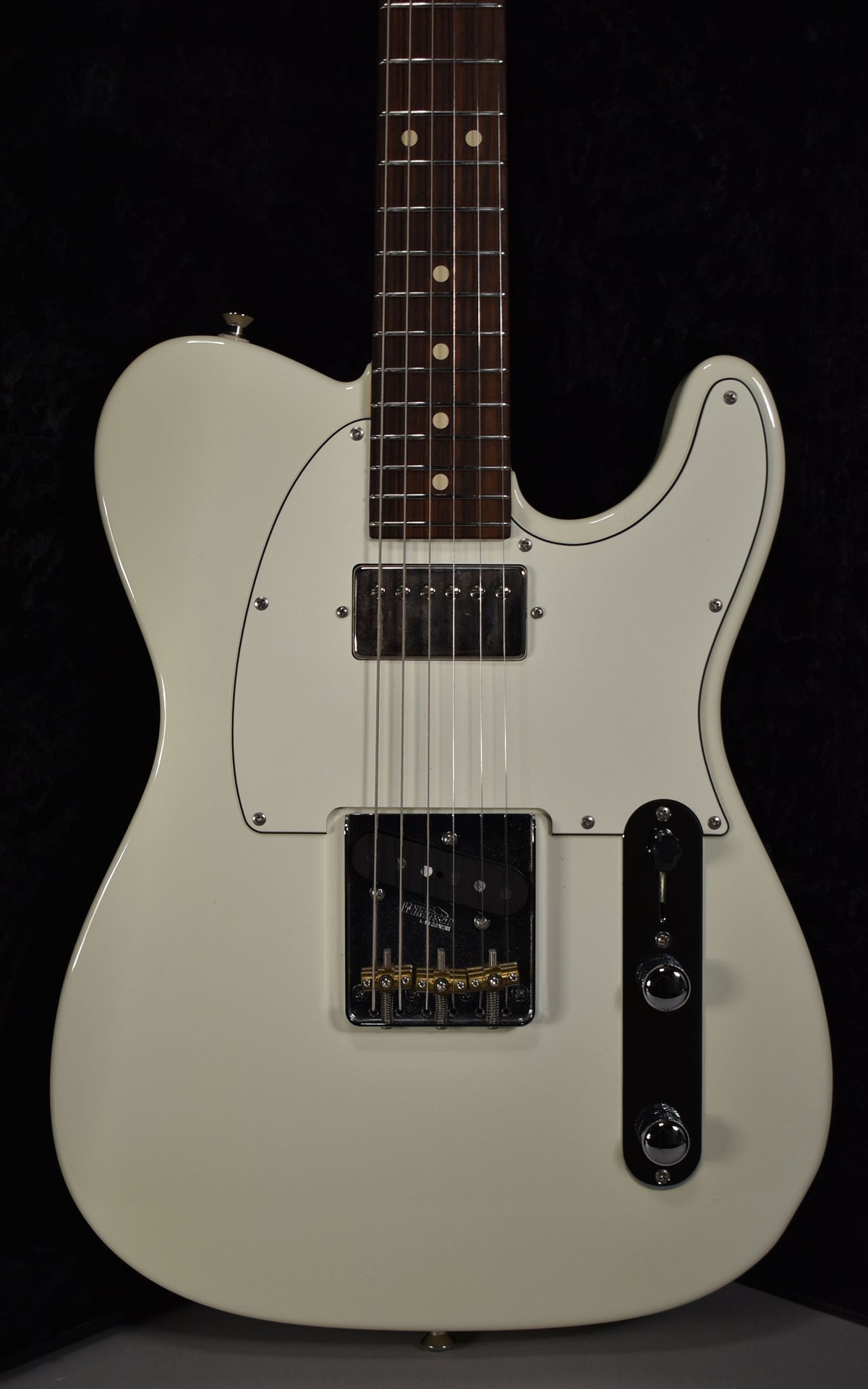 Full front view of the Olympic White guitar, showing a humbucker neck pickup, a single-coil bridge pickup, and gold saddles.