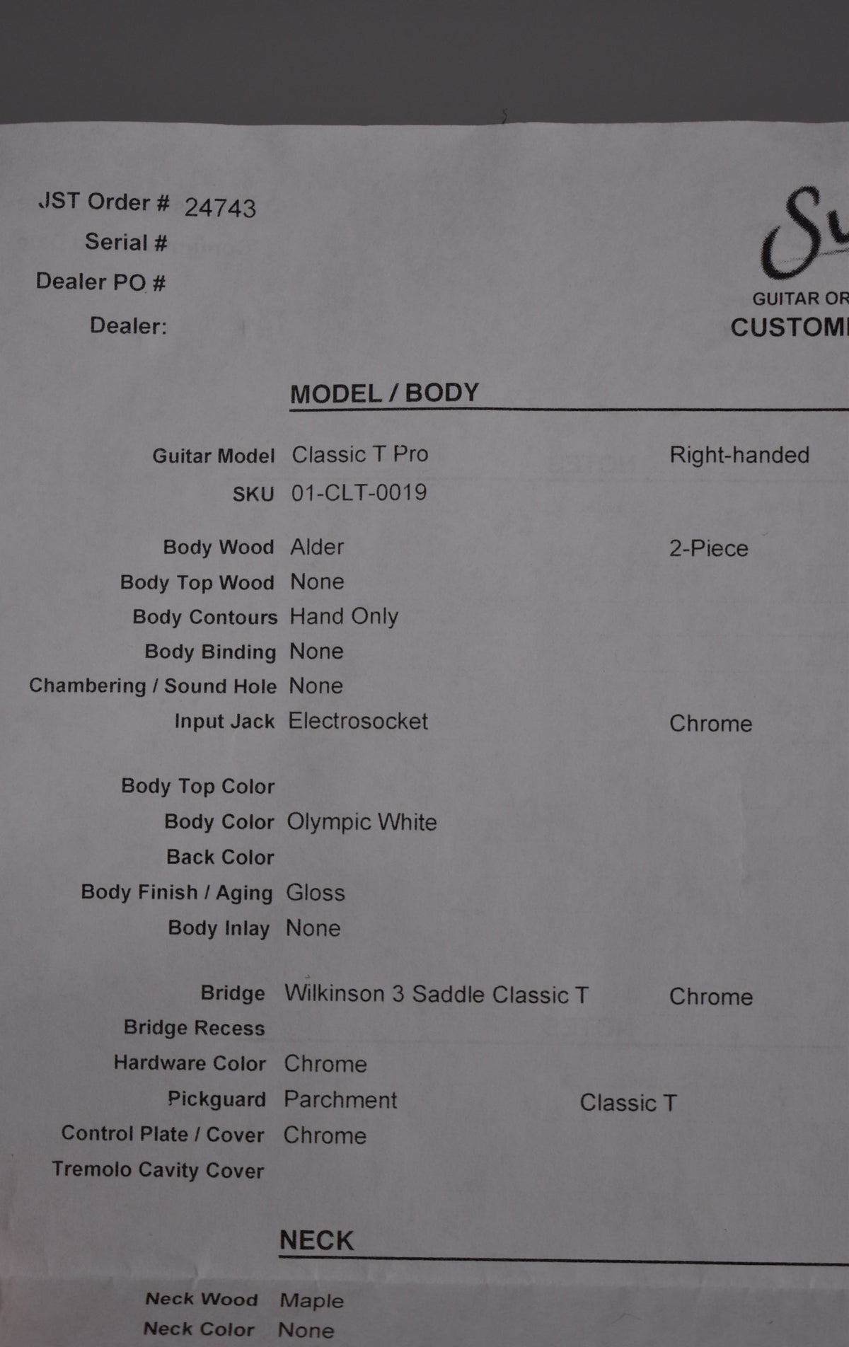A close-up of a white paper spec sheet for the Suhr Classic T Pro, detailing body wood, color, finish, and hardware.