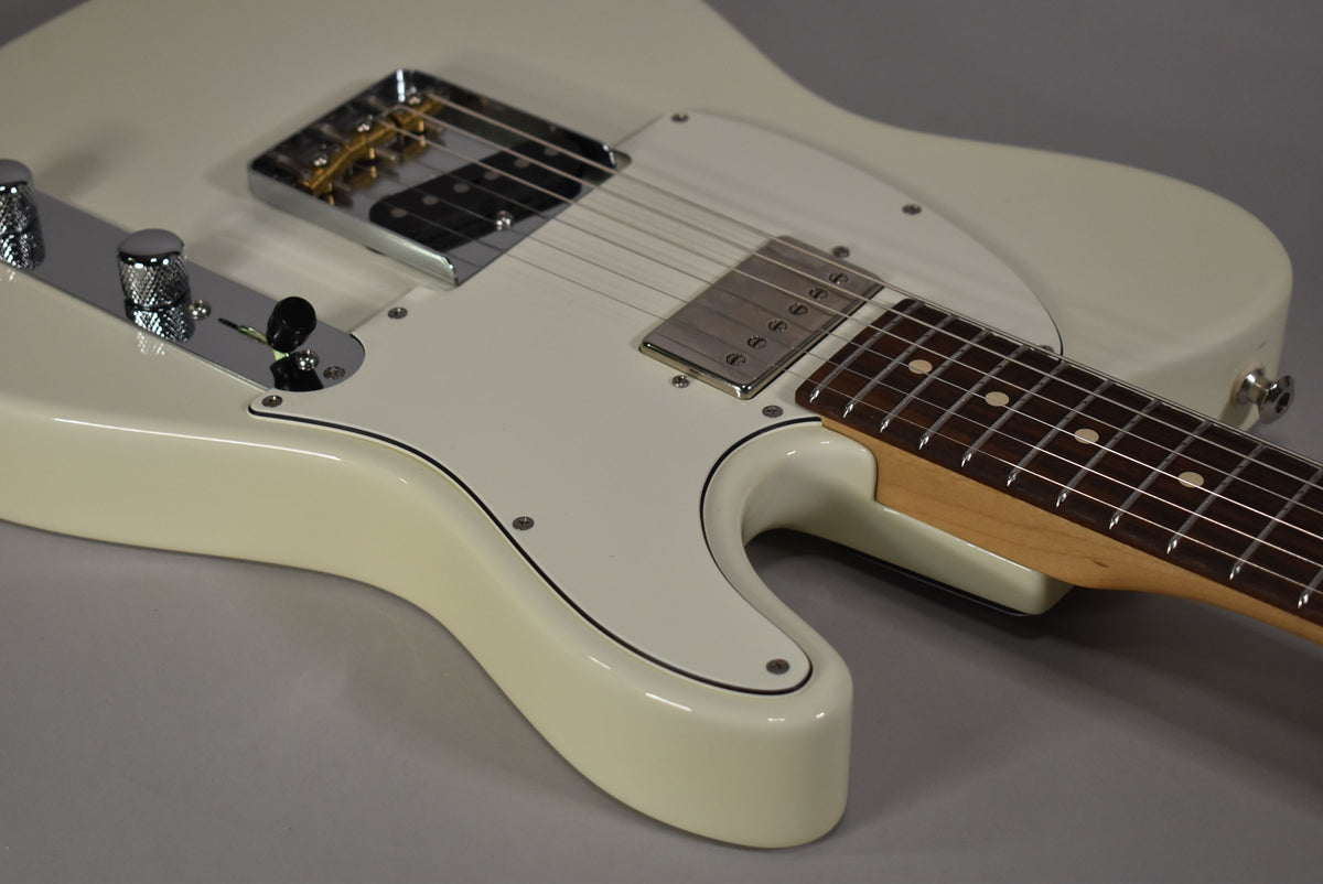 Close-up of the Olympic White guitar body, showing the chrome bridge, neck pickup, white pickguard, and rosewood fretboard.
