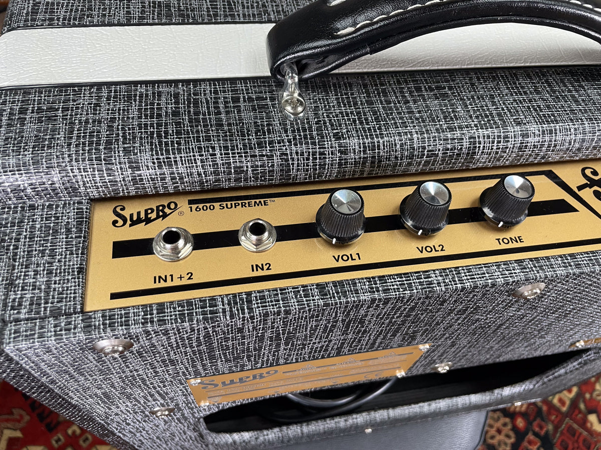 Close-up of the amp's top and front, showing the gold control panel with two inputs and three black knurled knobs.