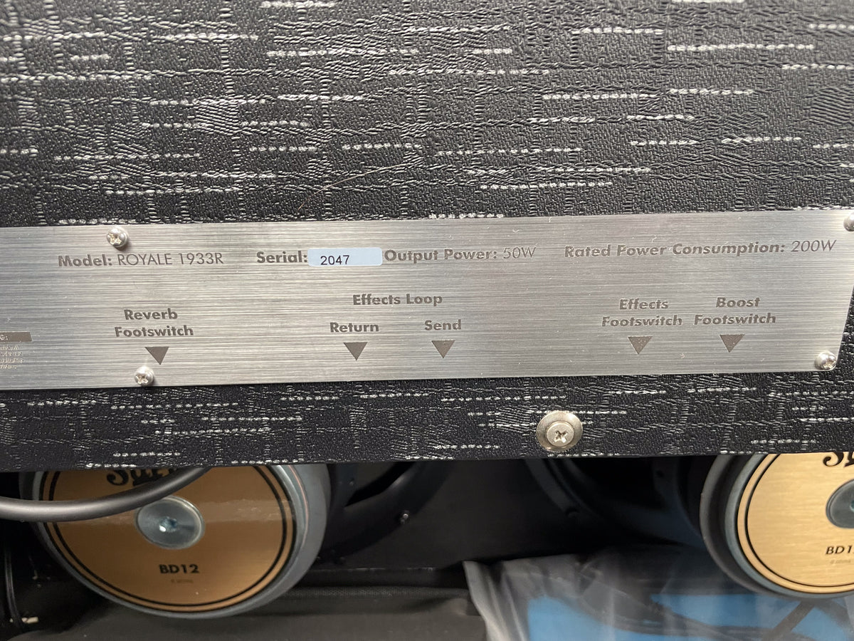 Close-up of the amp's brushed metal rear panel, showing the serial number, output power, and footswitch jacks.