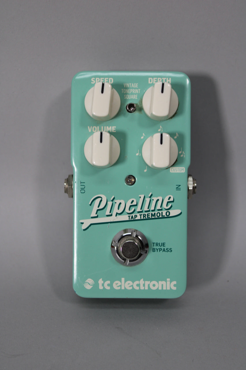 Top-down view of a rectangular, seafoam green pedal with four white knobs, a small toggle switch, and a chrome footswitch.