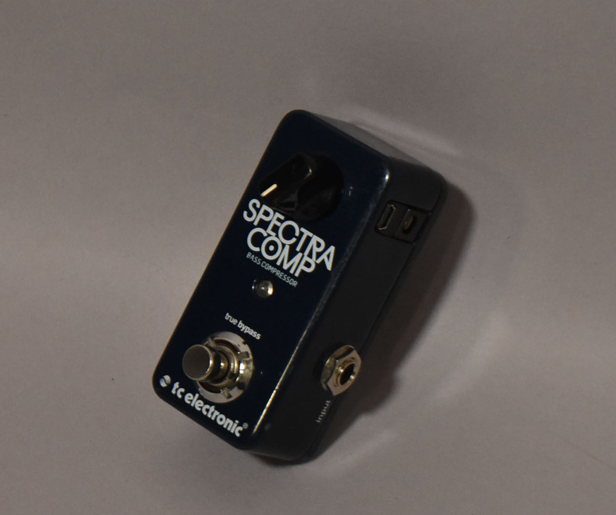 Dark blue mini pedal, angled from above, showing a single black knob, footswitch, and input jack.