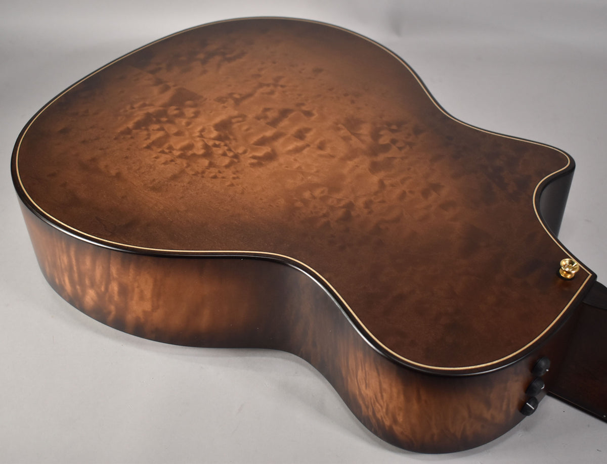 The guitar's back and side are angled, showing the dark brown burst finish with prominent wood grain and a gold strap button.