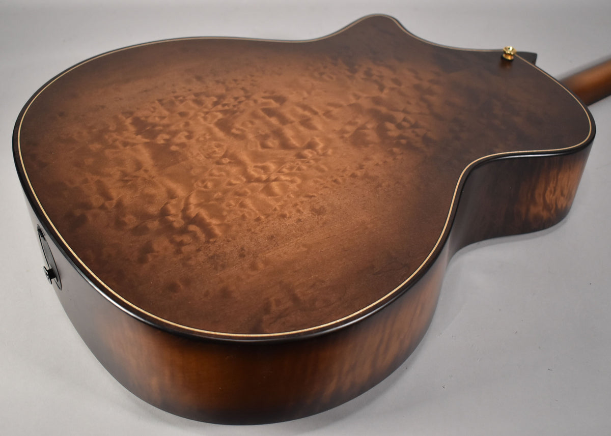 The guitar's back and side are angled, showing the figured maple Wild Honey Burst finish and a gold strap button.