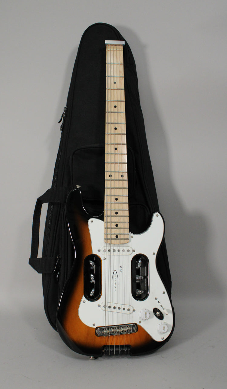 A sunburst headless electric guitar with a white pickguard and exposed tuners, standing upright in a black gig bag.