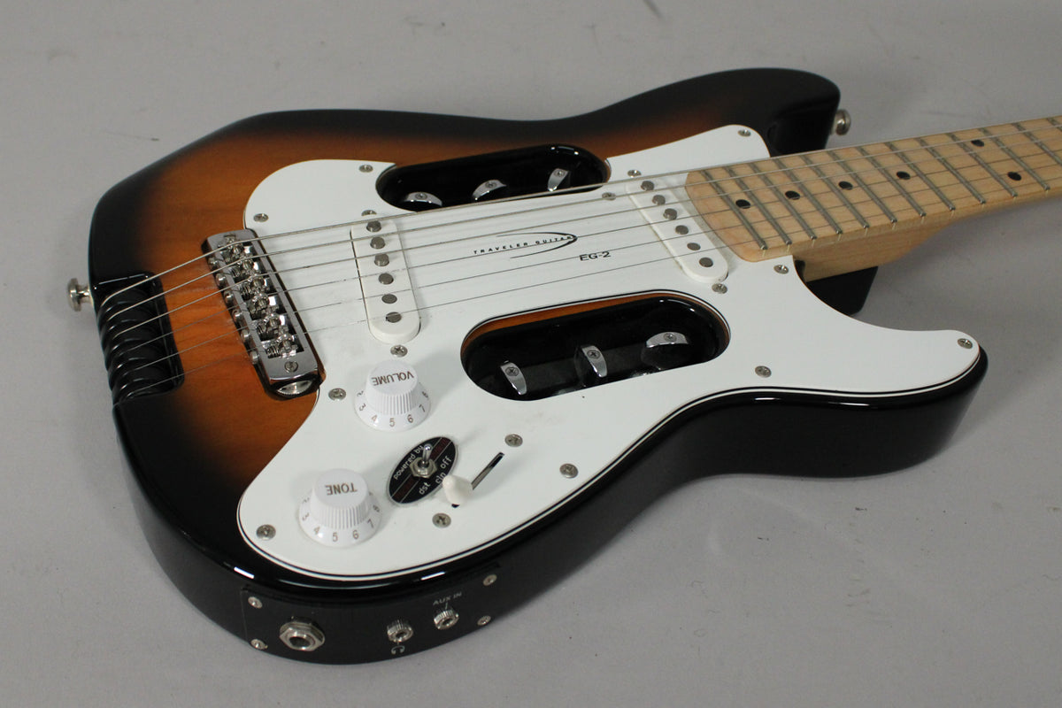 A sunburst electric guitar with a white pickguard, two white knobs, a toggle switch, and a maple fretboard.