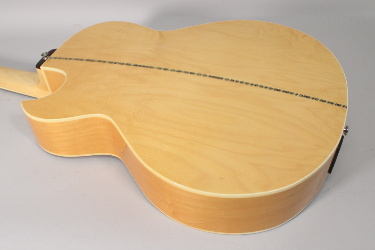 The natural finish acoustic bass's back and side are visible, showing a light wood grain and a dark center strip.