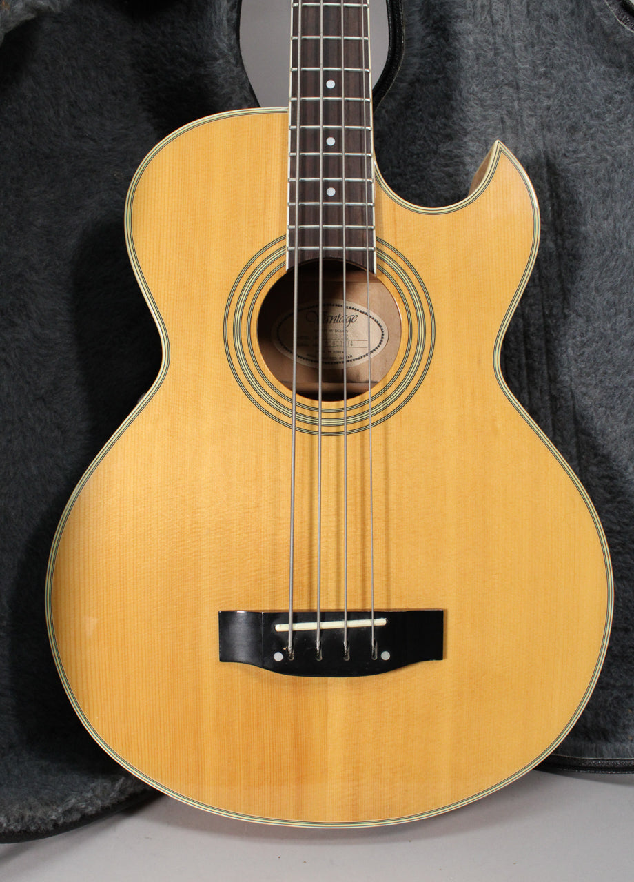 Full-front view of a natural finish acoustic bass with a cutaway, dark fretboard, and black bridge.