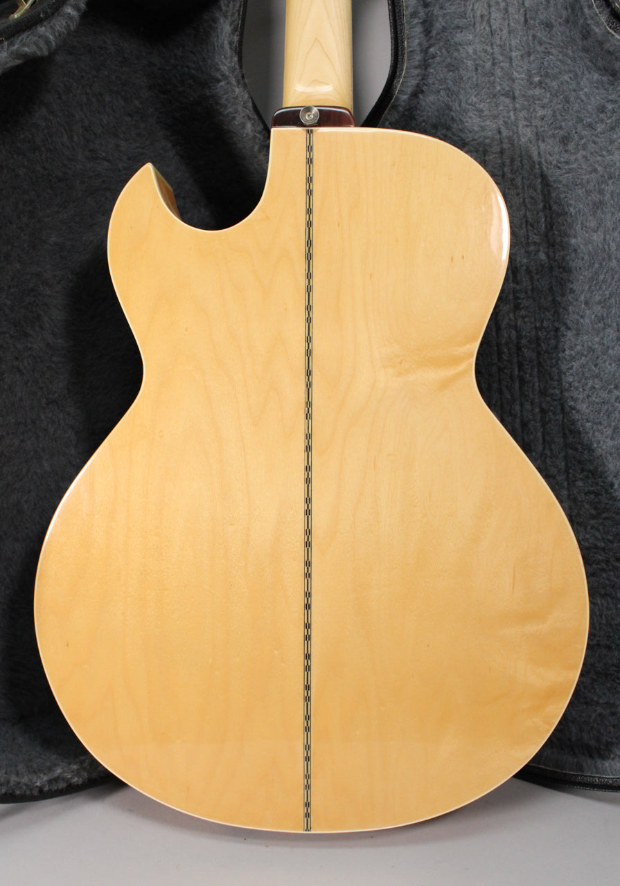 The natural finish acoustic bass's back and neck heel are visible, showing a dark center strip and light wood grain.