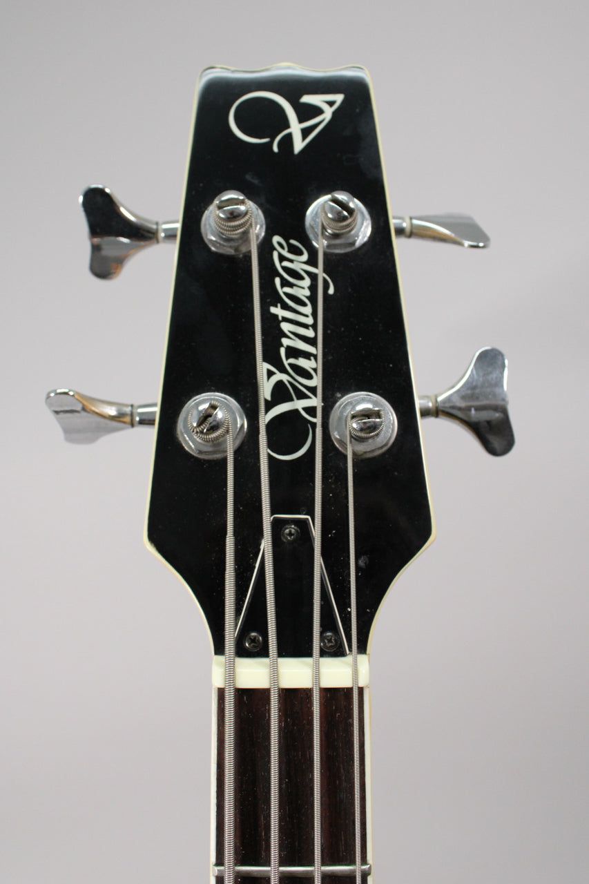 Close-up of the black headstock with chrome tuners, showing the top of the dark fretboard and cream nut.
