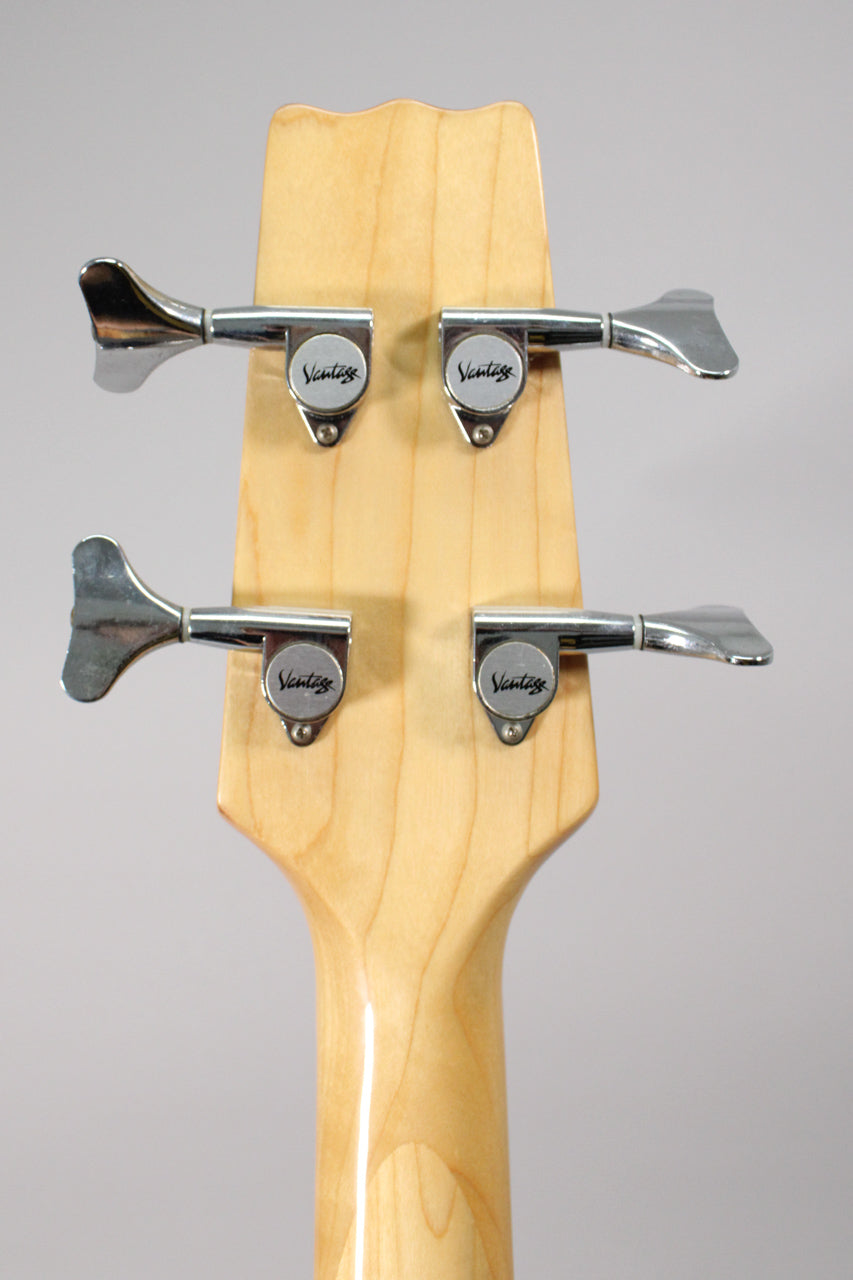 The back of the natural finish headstock and neck, showing four chrome tuners with paddle-shaped keys.