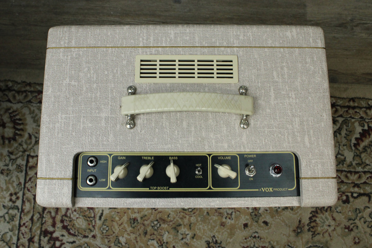 Top-down view of the fawn-colored amp, showing the cream-colored handle, vent, and control panel with black knobs and a red jewel light.