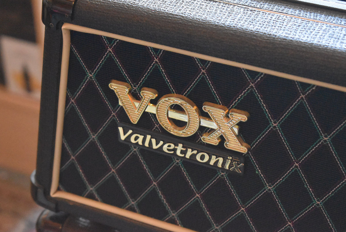 Close-up of the black diamond-patterned grille cloth with gold piping, showing the gold Vox Valvetronix logo.