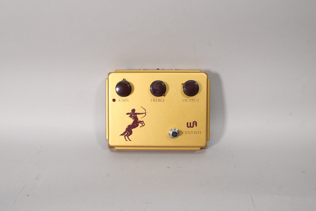 A gold-colored pedal with three dark brown knobs labeled Gain, Treble, and Output, a red centaur graphic, and a silver footswitch.