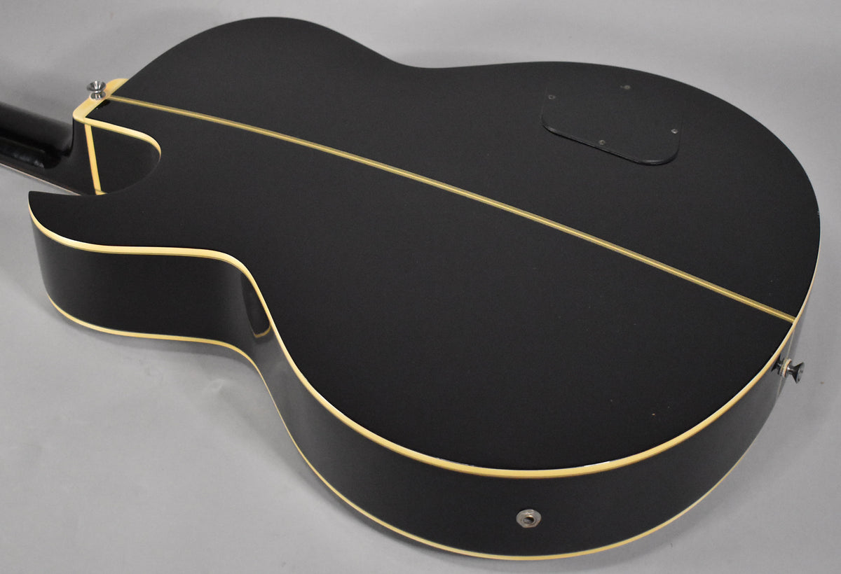The bass's black back and sides are shown from the lower bout, with cream binding and a light-colored center seam strip.