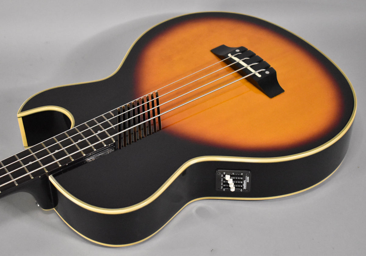 The sunburst hollowbody bass, angled from the lower bout, shows its black back, cream binding, and built-in preamp with sliders.