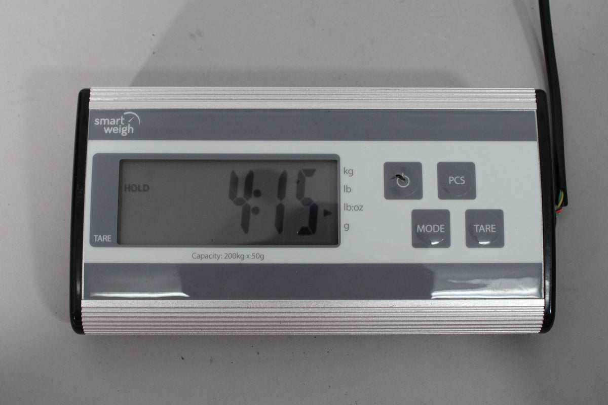 A digital scale shows "4.15" in large black numbers on its screen, with "lb:oz" illuminated next to it.