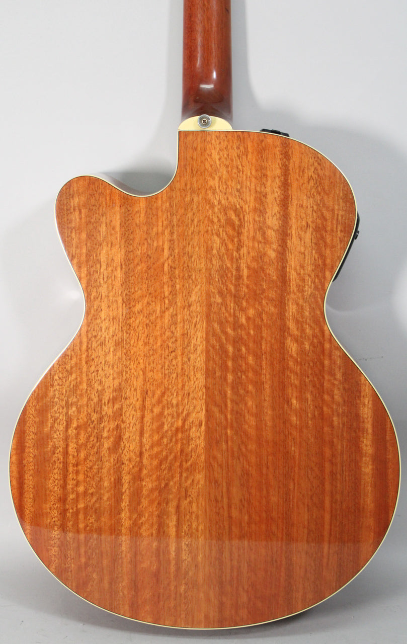 The back of a reddish-brown acoustic guitar with a cutaway, showing the neck joint and cream binding around the body.