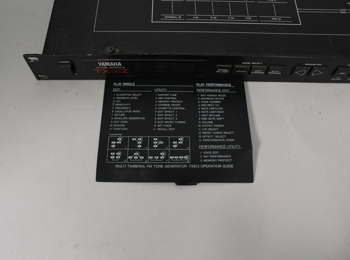 A black rackmount tone generator, angled from the left, with a black operation guide card pulled out from beneath the unit.