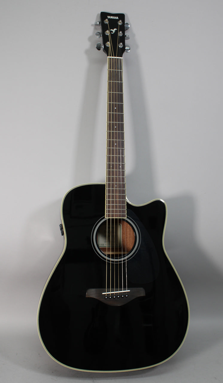 Full-length view of a glossy black dreadnought acoustic-electric guitar with a cutaway, chrome tuners, and a light wood soundhole.