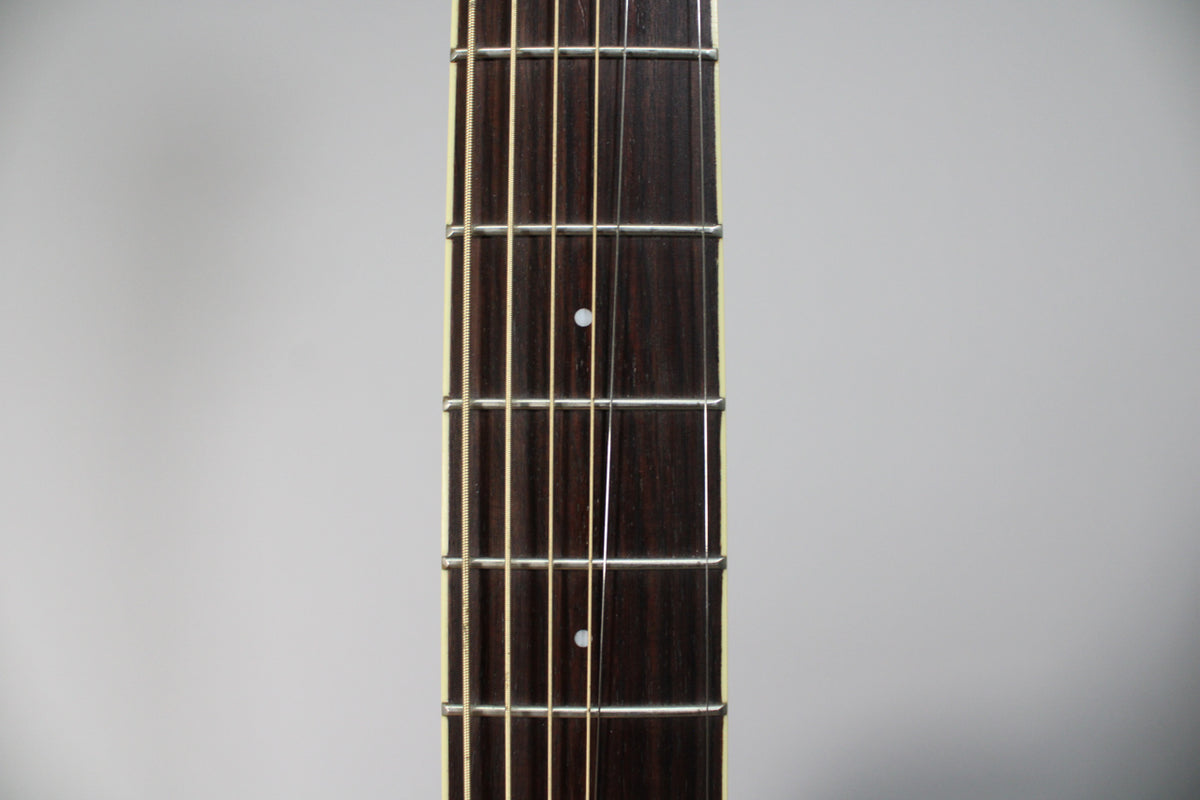 Close-up of the dark brown fretboard with white binding, showing frets 3 through 8 with two small white dot inlays.