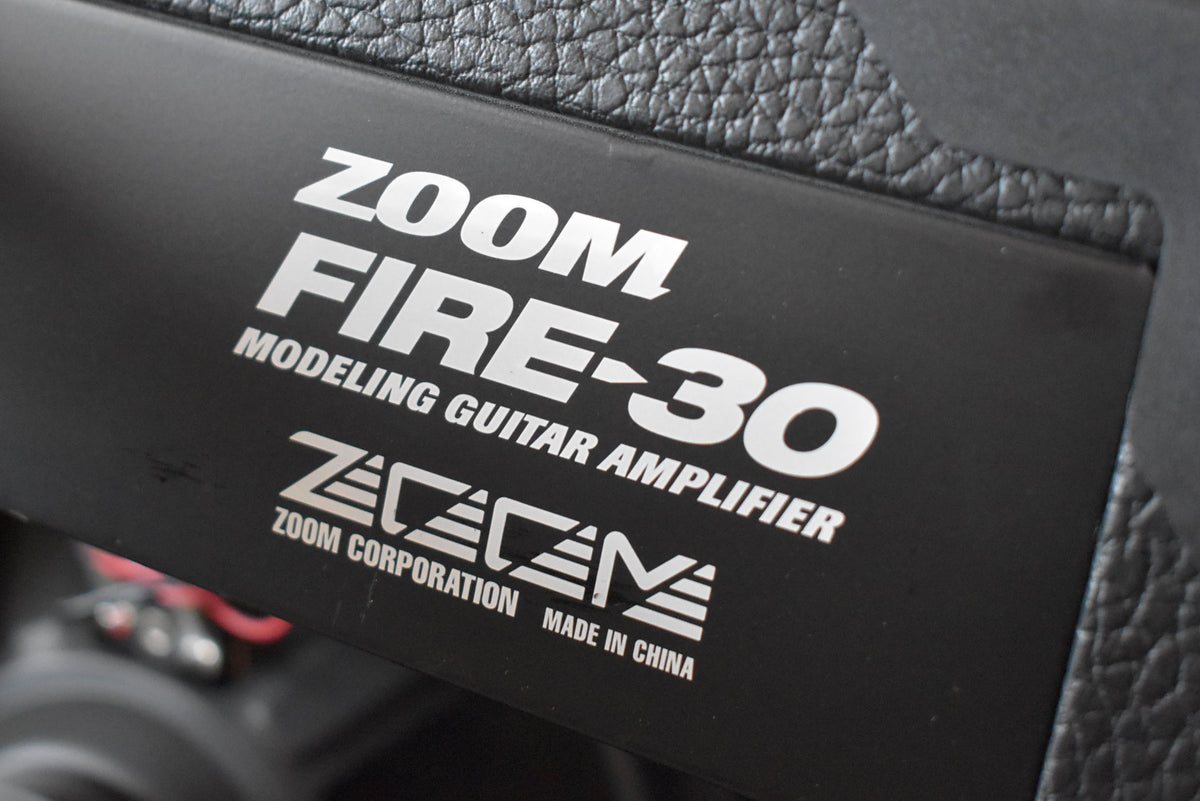 Close-up of the amp's black control panel, showing white lettering and a textured black vinyl covering along the top edge.