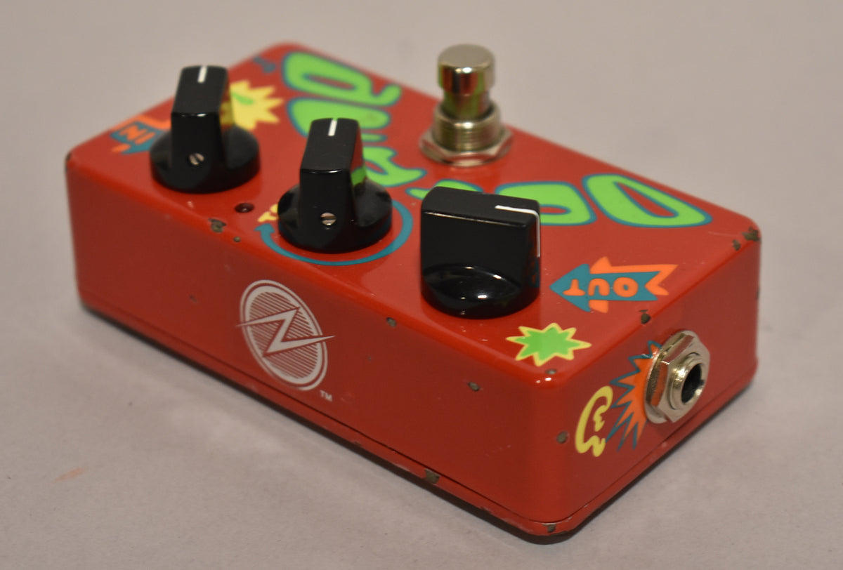 A red effects pedal with hand-painted green and blue graphics, three black control knobs, a silver footswitch, and an input jack on the right side.