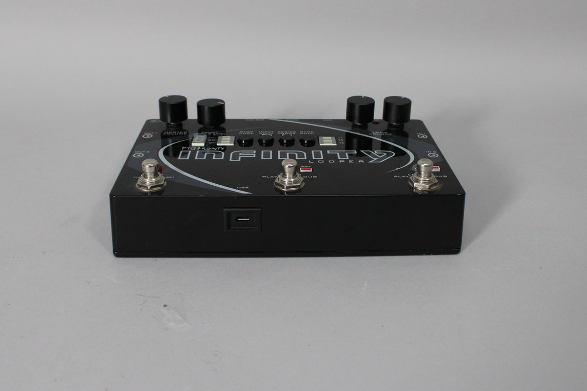 A black guitar pedal with a glossy finish, four black knobs, three silver footswitches, and a USB port on the front.