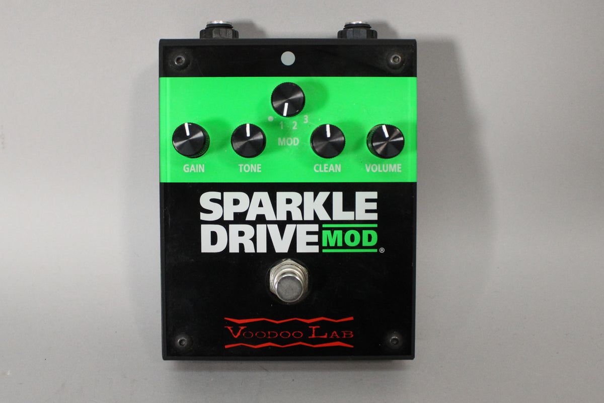 Top-down view of a black and neon green pedal with five black knobs and a silver footswitch.