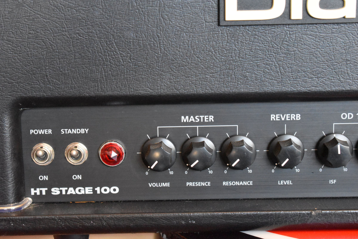 Close-up of the black textured amp head's control panel, showing toggle switches for Power and Standby, a red jewel light, and several black knobs.