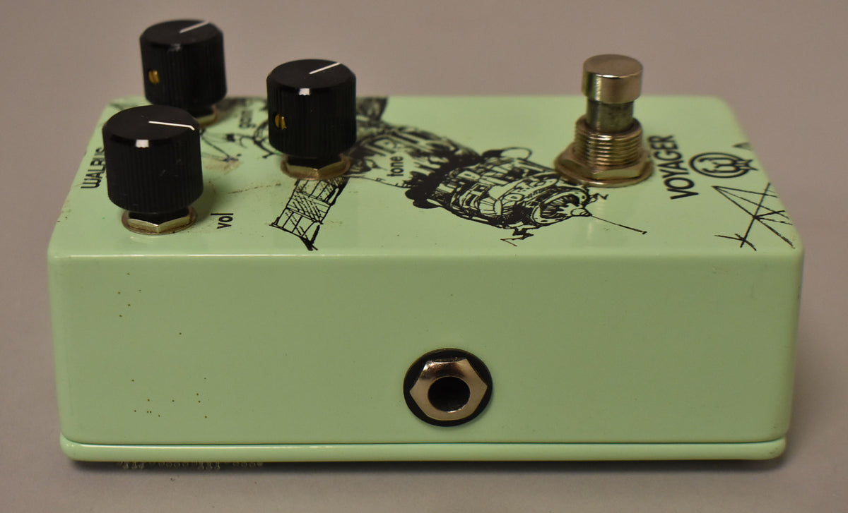 The light green effect pedal is angled to show its right side and top, featuring three black knobs, a gold footswitch, and a 1/4" input.