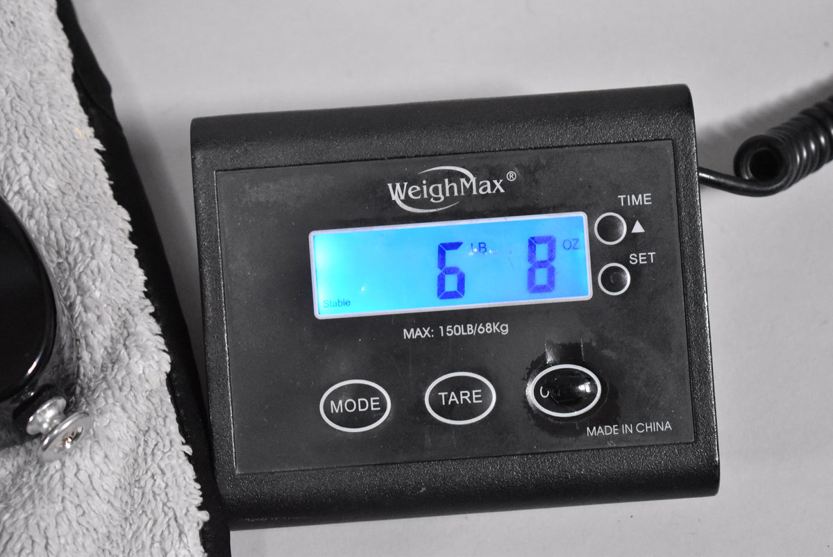A digital scale displays "6 LB. 8 OZ." on a blue screen, with a coiled black cable visible on the right.