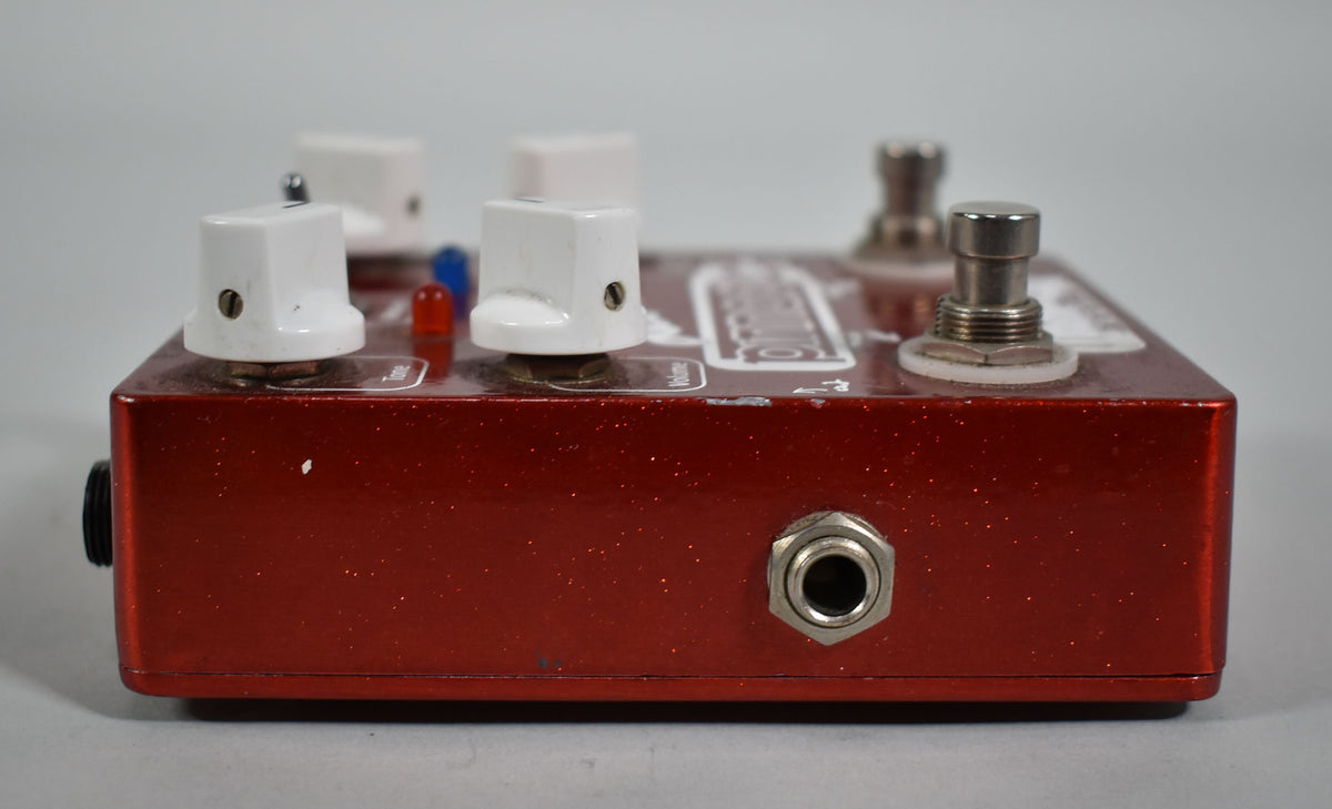 A red glitter Wampler Pinnacle Deluxe Overdrive V1 pedal, showing the right side with an input jack and part of the top with knobs and switches.