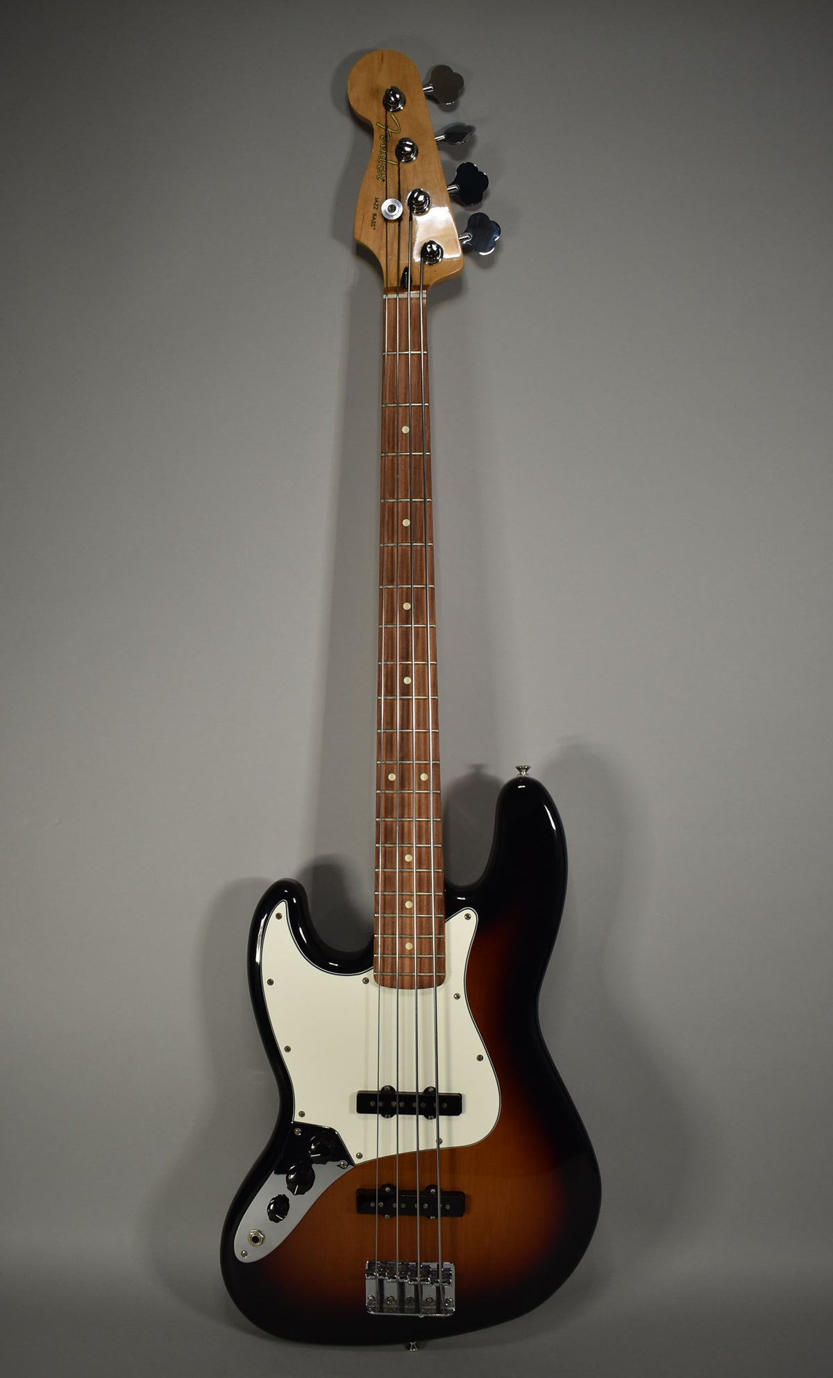 Full-length, front view of a left-handed 3-Tone Sunburst bass with a white pickguard and rosewood fretboard.