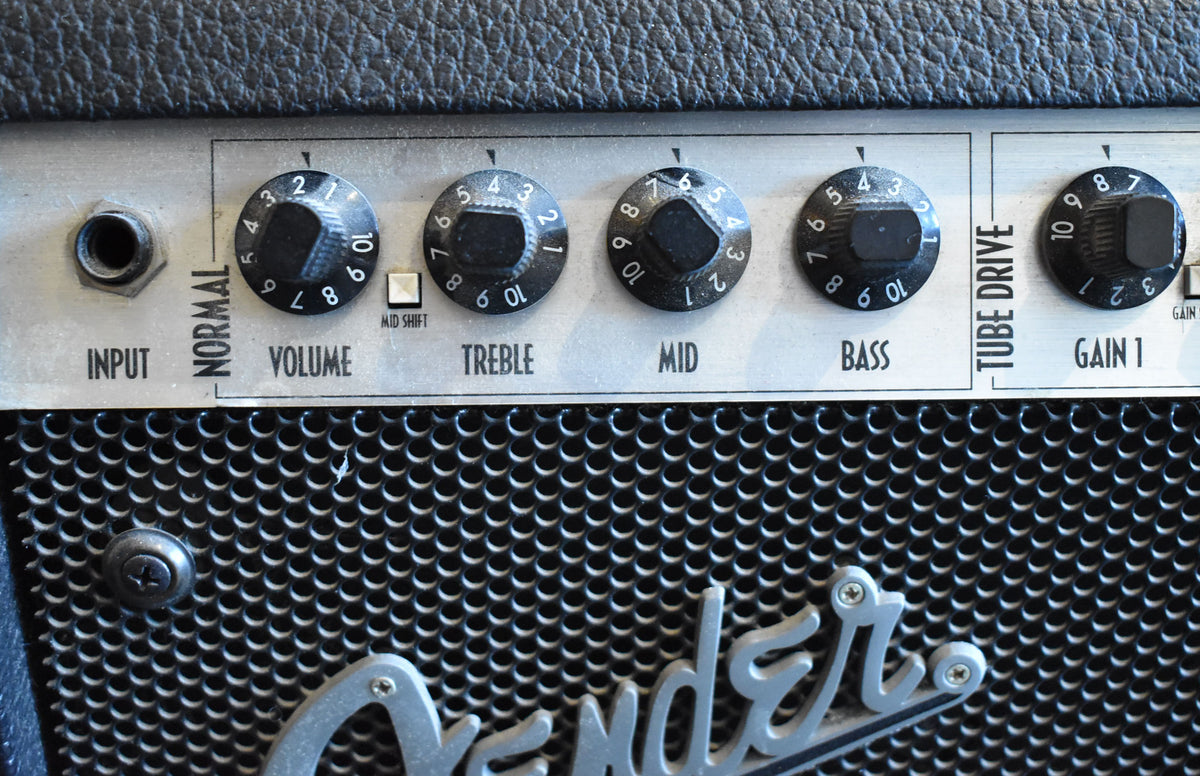 Close-up of the amp's silver control panel with black knobs, showing the input jack, "Normal" and "Tube Drive" channels.
