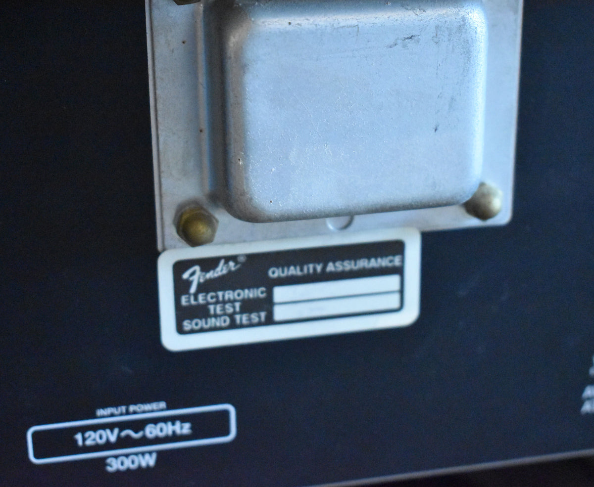 Close-up of the amp's black rear panel, showing a silver transformer, a white quality assurance sticker, and "120V~60Hz 300W" text.