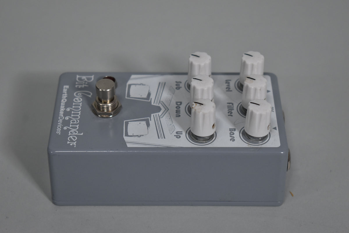 A gray effects pedal with a silver footswitch and six white knobs, viewed from the top-right with some label wear.