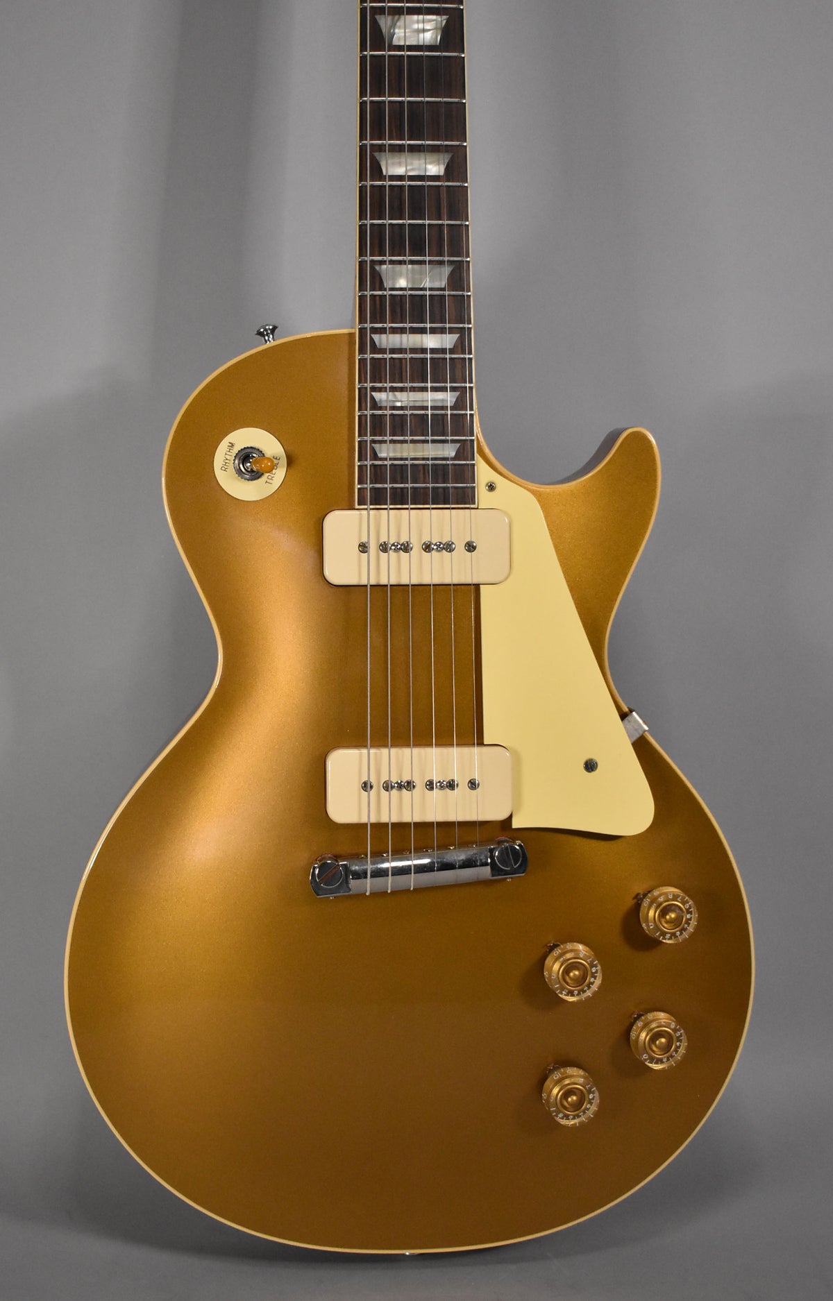 A goldtop Les Paul guitar with cream P90 pickups, a cream pickguard, and gold volume/tone knobs.