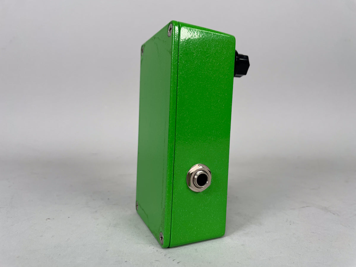 The lime green sparkle pedal is viewed from the right side, showing a chrome input jack and a black control knob on top.