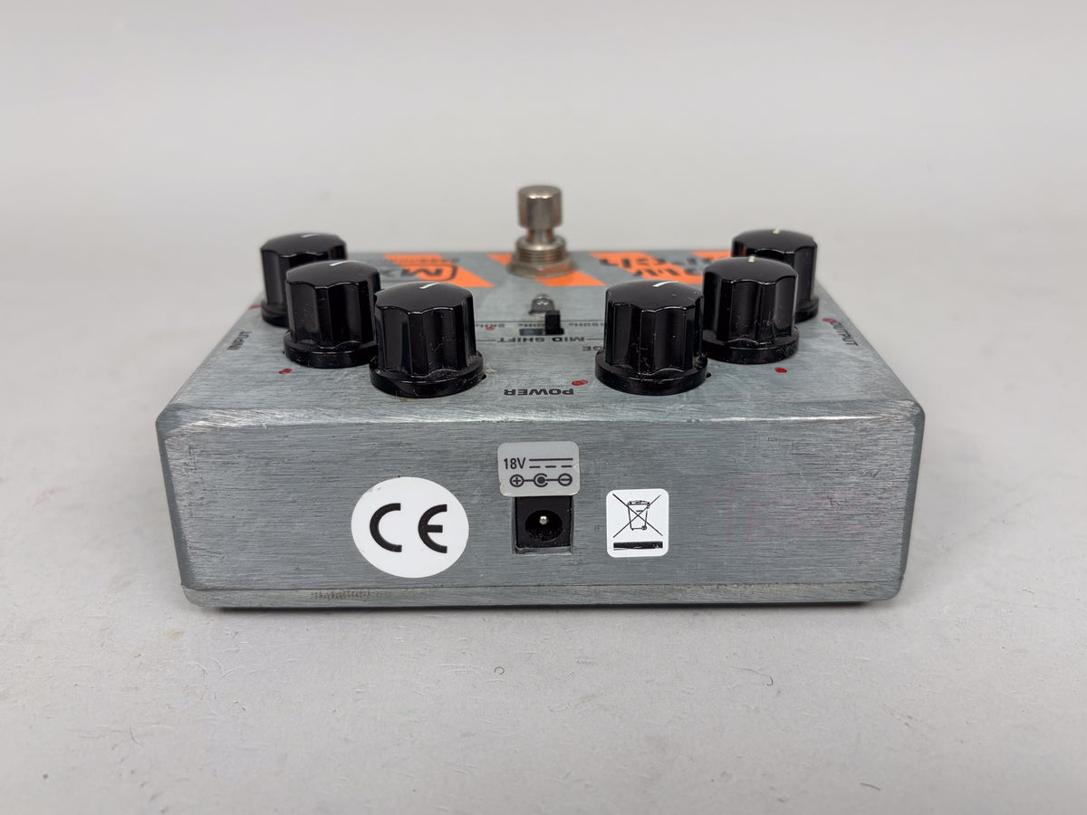 The silver pedal is viewed from the rear, showing the 18V power input and a CE mark sticker.