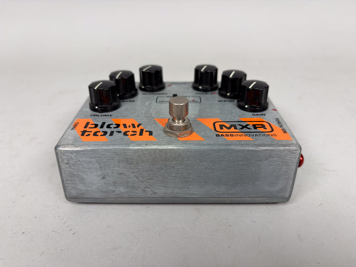 A gray MXR Blow Torch Bass Innovations overdrive pedal with 7 black knobs and a silver footswitch.
