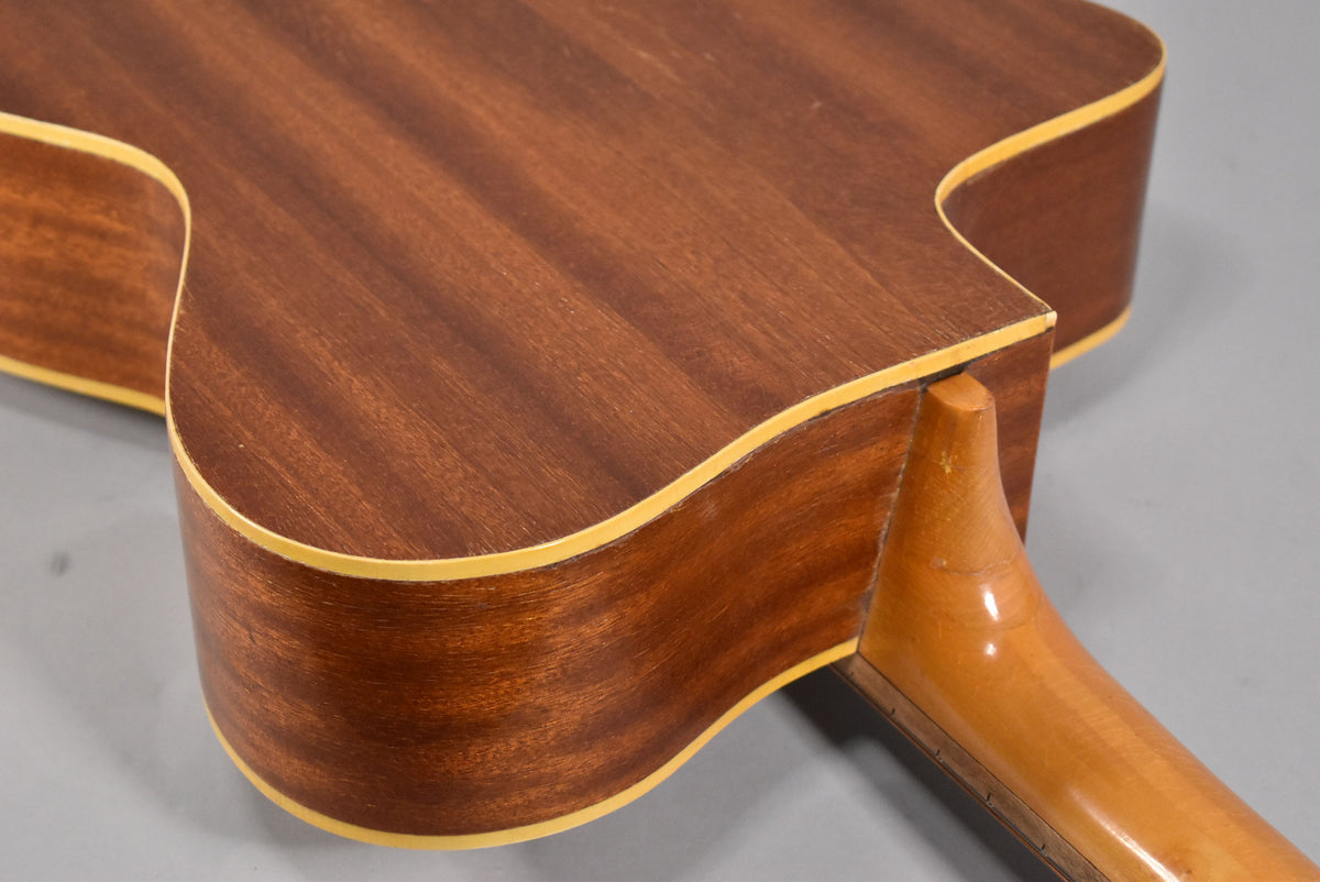 Close-up of the guitar's lower bout and neck heel, showing the dark natural wood finish and light binding, with some wear on the neck.