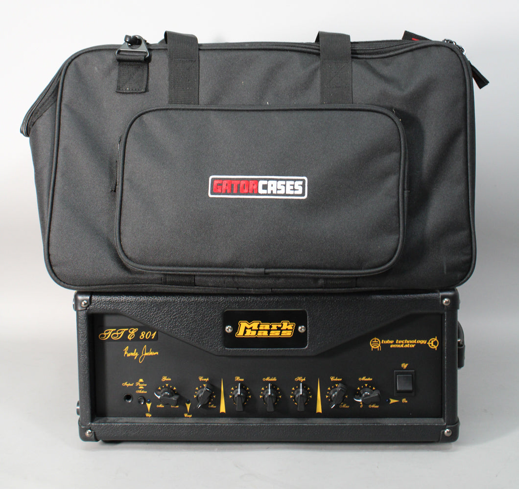The black amp head with a textured finish is shown from the front, with a black Gator Cases bag resting on top.