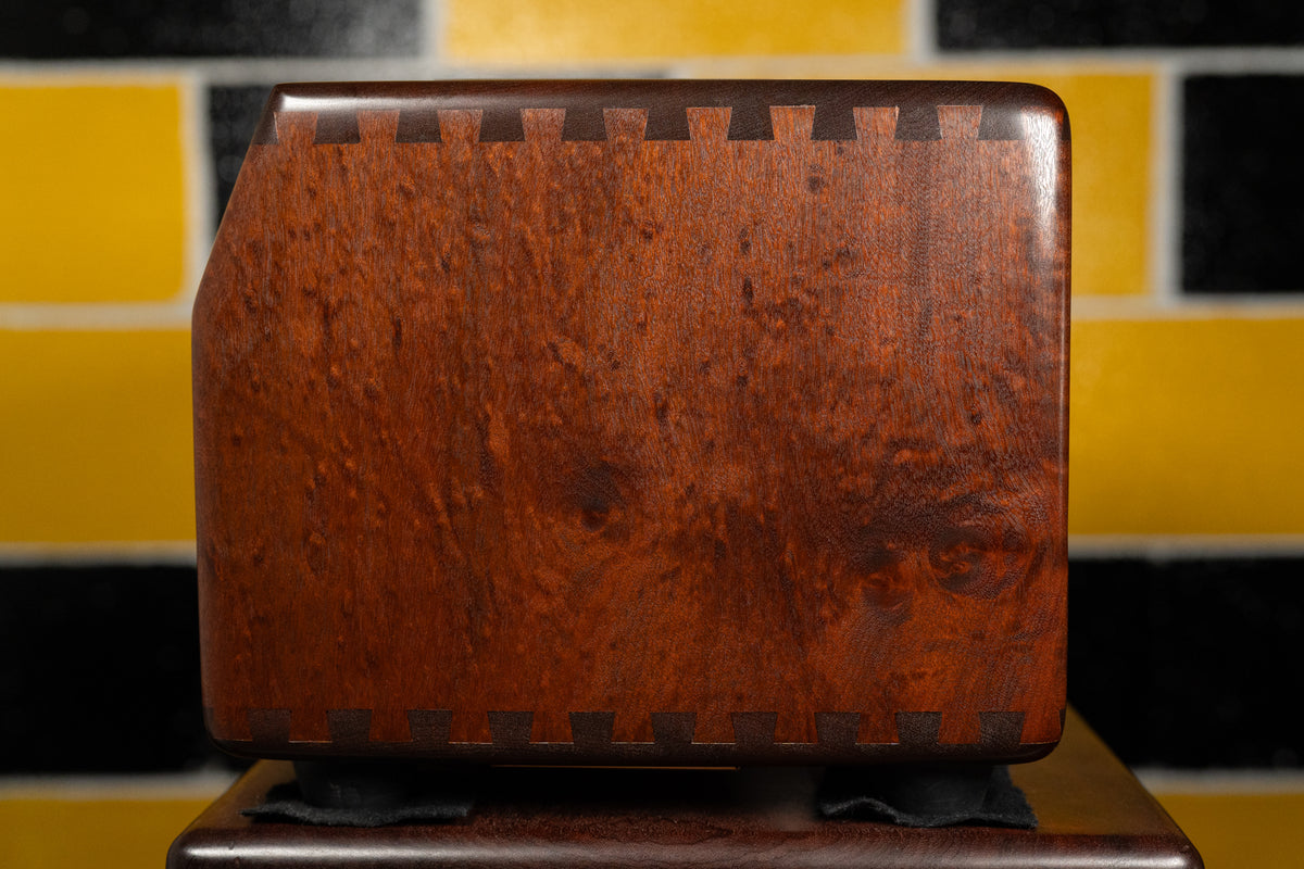The right side of the amp head, showing the dark wood grain and visible dovetail joints along the top and bottom edges.