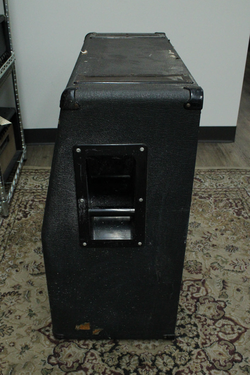 Right side of the black textured cabinet, showing a recessed handle, metal corner protectors, and scuffs on the top and bottom edges.