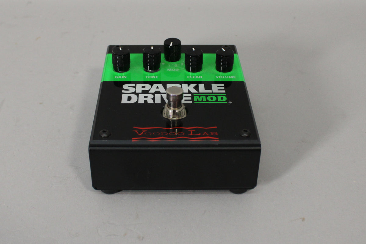 Black pedal with a bright green stripe across the top, featuring five black control knobs and a chrome footswitch.