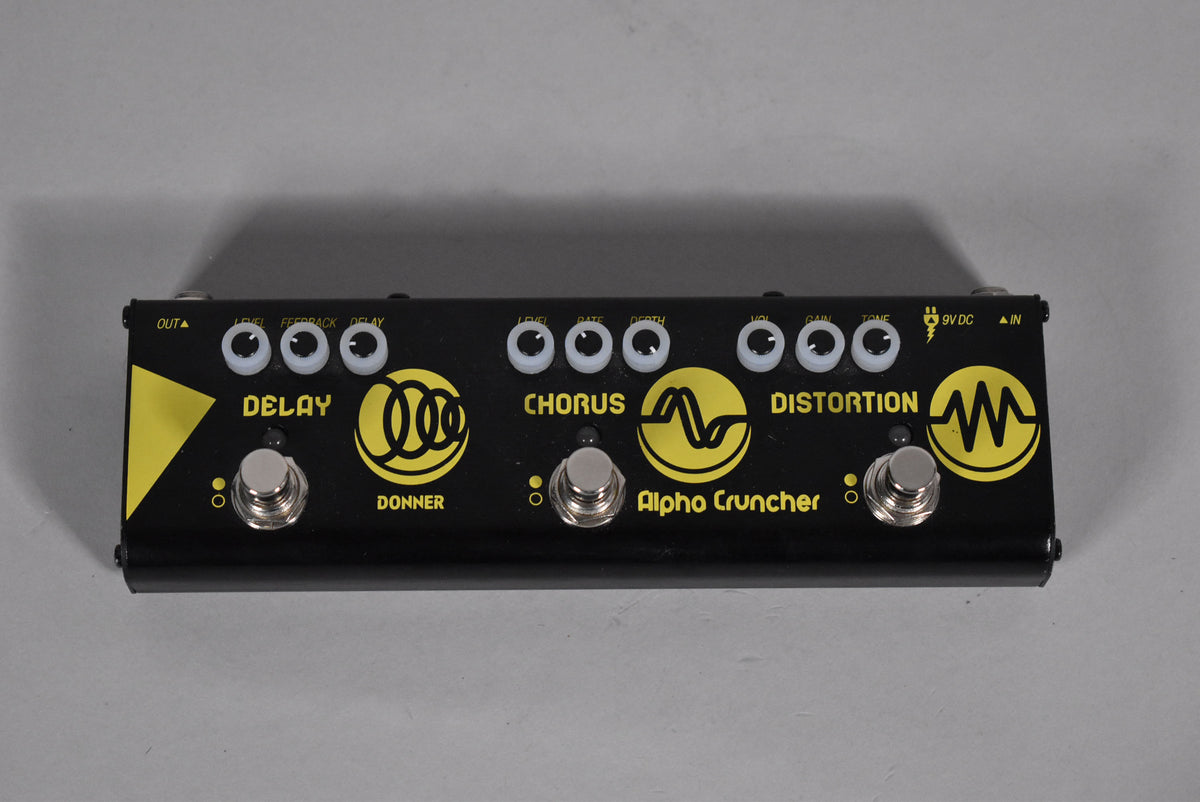 A black multi-effects pedal with three footswitches and nine white control knobs, featuring yellow graphics for Delay, Chorus, and Distortion.