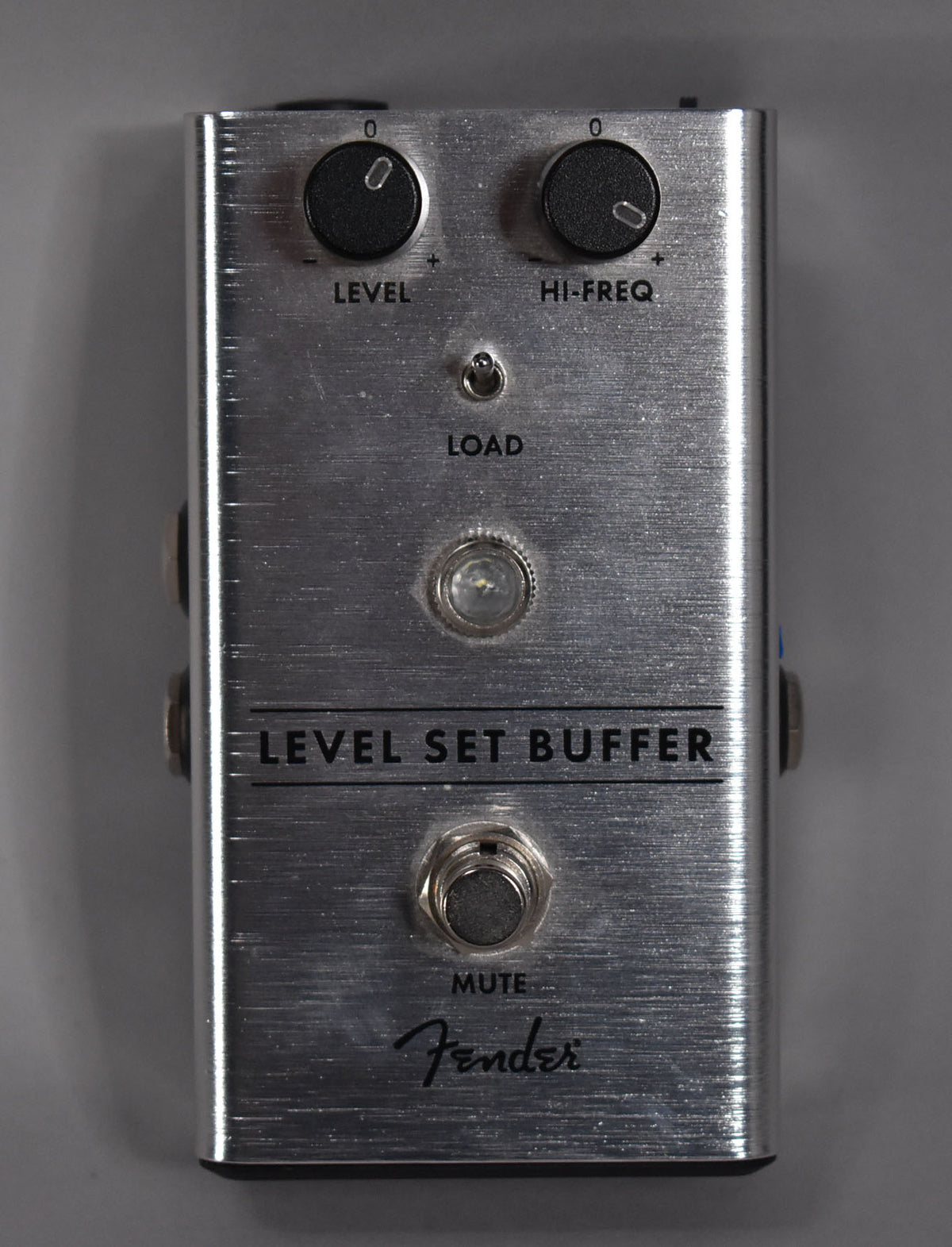 Overhead view of a brushed silver pedal with two black knobs, a toggle switch, a clear LED, and a footswitch.